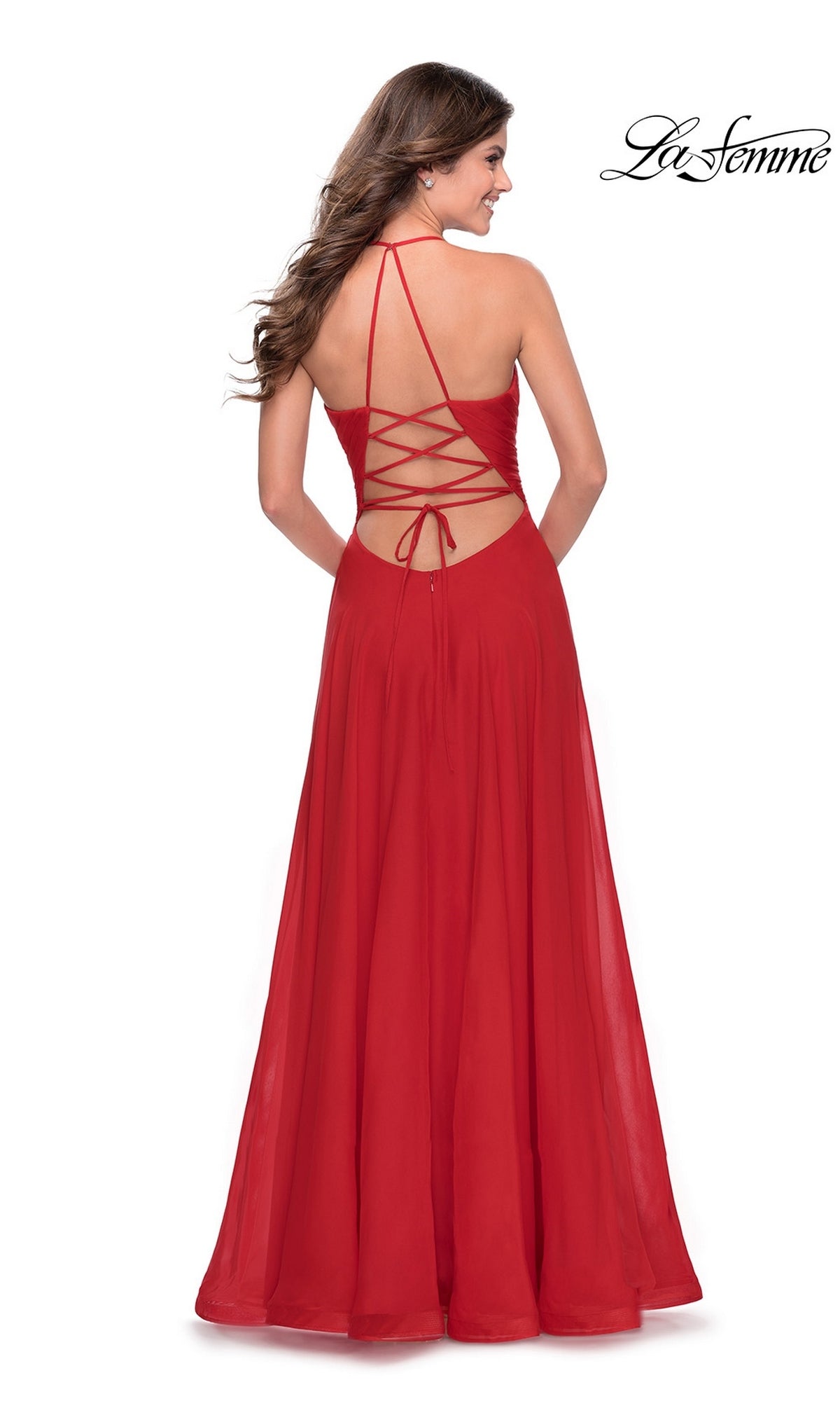 Back view of a woman in a floor-length red chiffon Long Prom Dress: La Femme 28522, featuring an A-line skirt and a lace-up open back with thin straps.